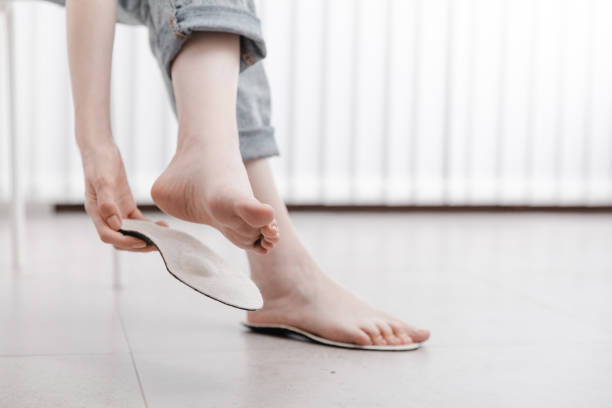 women-holding-white-prefabricated-insoles-for-her-feet